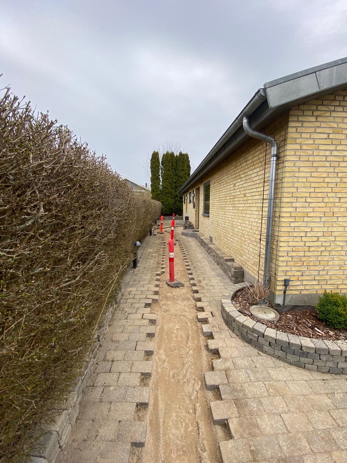Belægningssten taget op i en afgrænset strækning langs en bolig